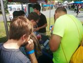 Faire visitors checking out floppy drive music with a calculator